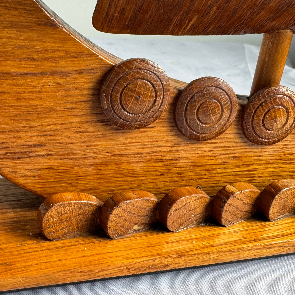 Detail of carved round shields and oars on Viking ship hull